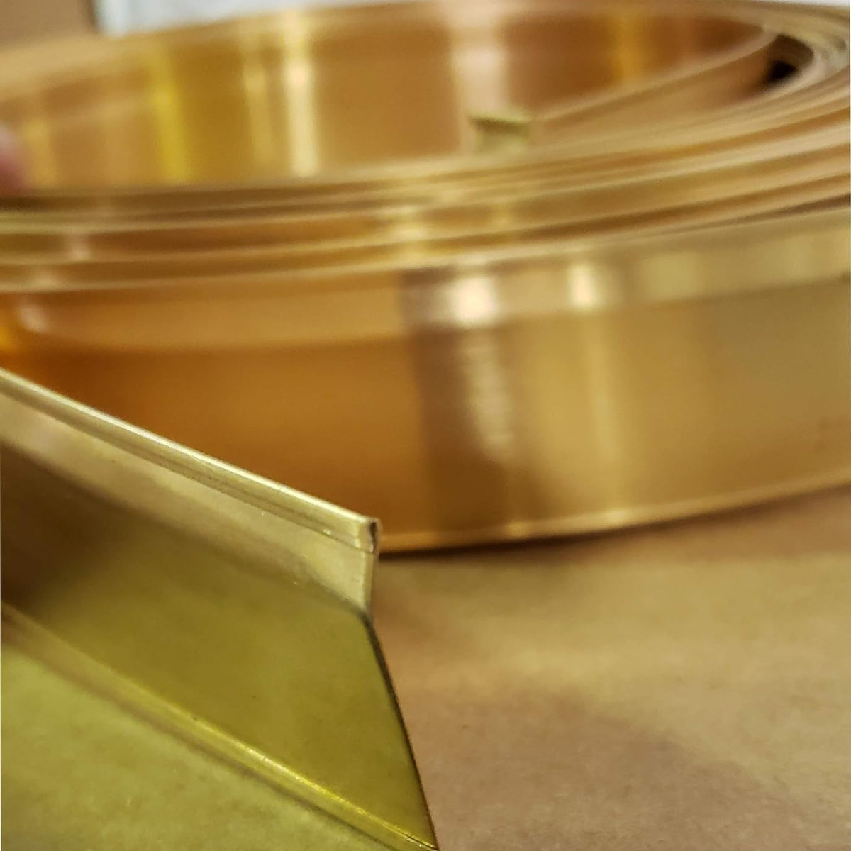 Close-up of bronze metal strip on a wooden surface